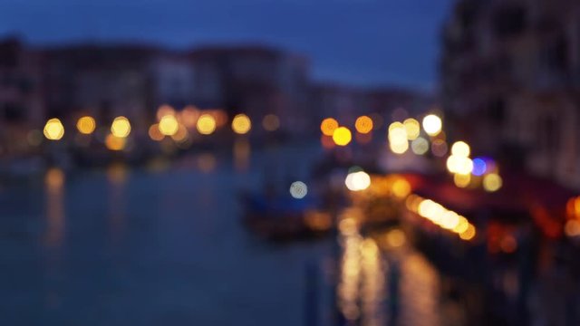 Bokeh shot of the Grand canal and Venetian cityscape at night Pretty city lights reflecting off the water in Venice Italy 4k