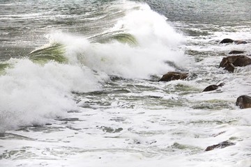 Rolling crashing waves on pebbles on a beach at Clarence Drive, between Kleinmond and Gordons Bay, Western Cape, South Africa.