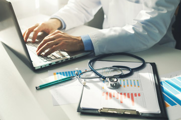 doctor working with medical statistics and financial reports in office - obrazy, fototapety, plakaty