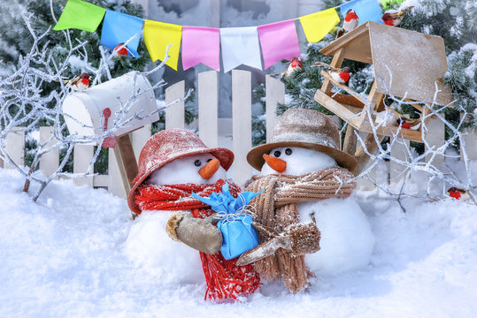 Postcard with Christmas and a new year with two cute snowmen