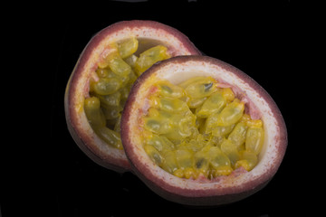 slices of passion fruit isolated on black background