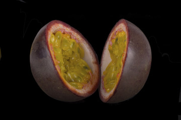 slices of passion fruit isolated on black background