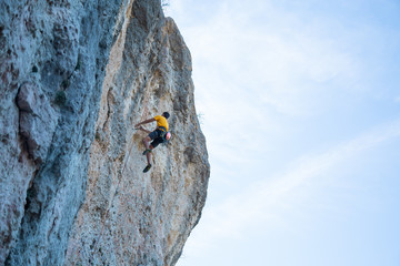 View of man without helmet hanging on a rope while rappelling and shows flying pirouettes in the air  © pablobenii