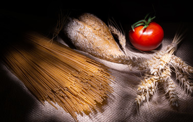 Wholemeal pasta and bread on rustic background