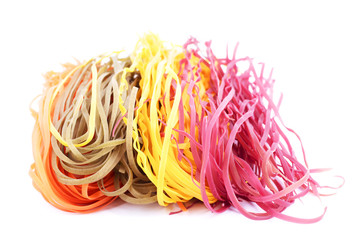 Towers from italian multicolored pasta tagliatelle on a white background