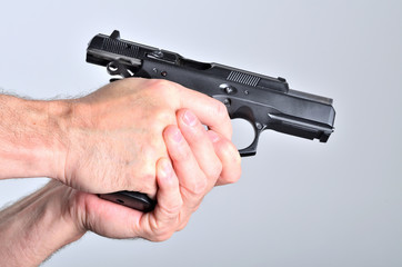 Hand of man with a pistol - side view
