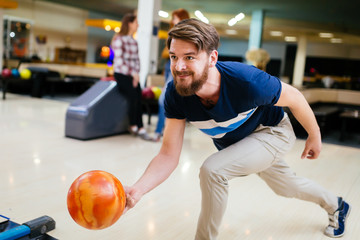 Fototapeta premium Cheerful friends bowling together and having fun