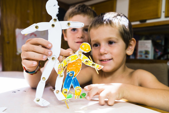 Two kids playing on a table with puppets in paper, Charlotteville, Tobago, Trinidad and Tobago, West Indies, South America