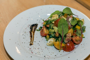 A beautiful dish on a white plate on the table in the restaurant.