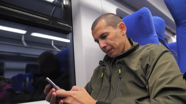 traveler unknown middle-aged man smartphone in the subway writes sms to social media messenger. man metro in railway train. man traveler in train concept lifestyle travel