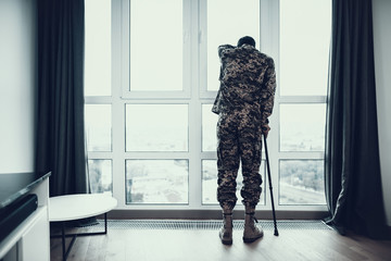 Soldier Stand with Hand on Window Leans on Crutch