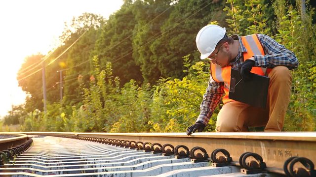 The railroad inspector checks the track to identify deficiencies before the repair is completed