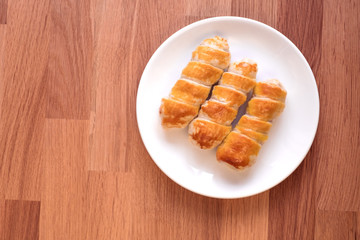 sausage in the dough on a white plate