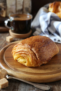 French breakfast: sweet puff pastry bun and cup of coffee