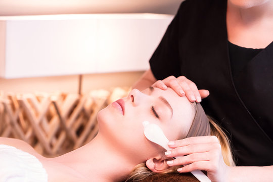 Beautician applying a skin care cream