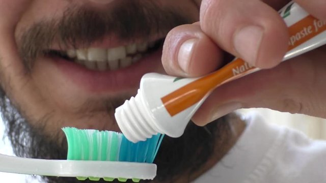 Man brushing teeth with toothpaste