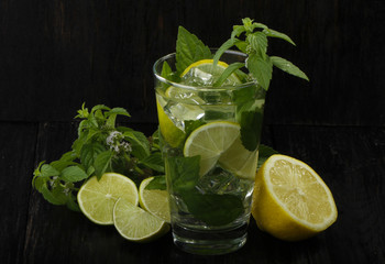 mojito with lemon, mint and ice isolated on wooden background