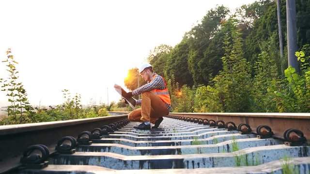 The railroad inspector checks the drawings and route map to identify gaps in the track