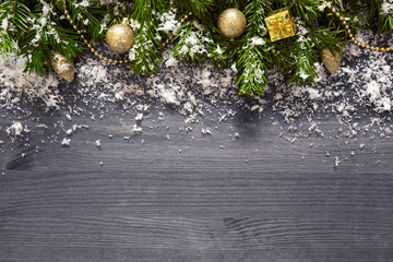 Christmas decorations and fir tree branches on wooden plank.