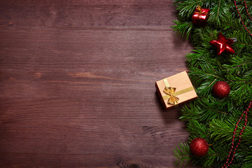 Fototapeta premium Christmas decorations, spruce branches and gifts on wooden surface.