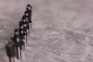Row of lot of steel router bits for milling cutter on old broken worn gray concrete floor with copy...