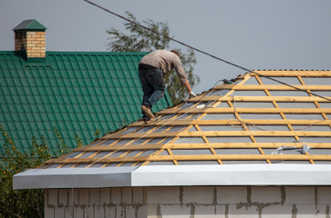 Worker covers the roof of the house