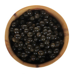 seeds of pawpaw in wooden cup isolated on white
