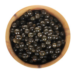 seeds of pawpaw in wooden cup isolated on white