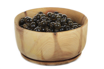 seeds of pawpaw in wooden cup isolated on white