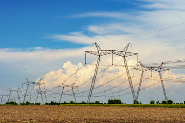high-voltage lines against the background of electrical distribution stations at sunrise.
