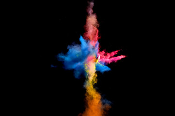 Colorful explosions of powder paint and flour combined  together explode in front of a black...