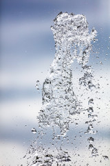 Splashing water with drops on the sky background