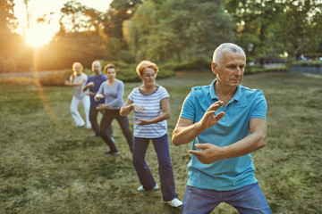 Group of people doing Tai chi in a park