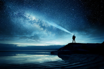 A person standing and watching the Milky Way galaxy rise into the night sky. Photo Composite - obrazy, fototapety, plakaty
