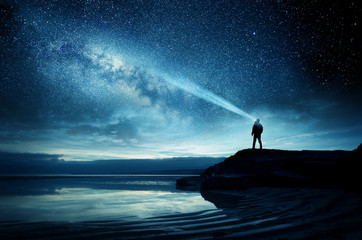 A person standing and watching the Milky Way galaxy rise into the night sky. Photo Composite