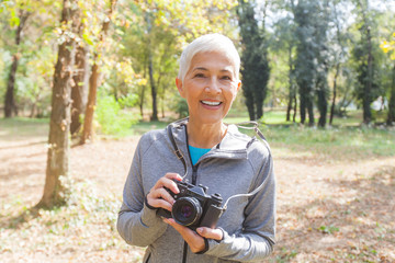 Happy Senior Woman With Retro Camera