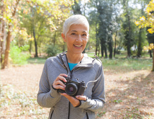 Happy Senior Woman With Retro Camera