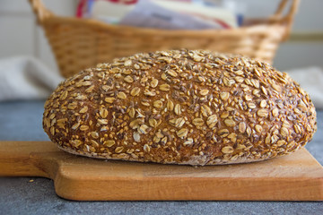 Bread on pergamet paper. Multi-grain healthy bread.Beautiful homemade bread sprinkled with grains on top.