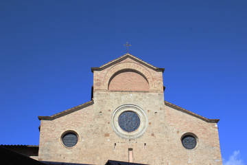 Clean shoot of masonry church facade with blue open sky in San Gimignano