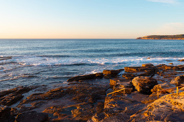 Fototapeta na wymiar Rocky beach coastline view with clear blue sky.