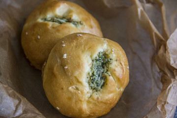  Homemade garlic buns for soup in parchment paper close-up.  Homemade yeast buns with garlic for soup in parchment paper close-up.
