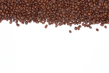 Coffee beans arranged on a white background as texture with copy space
