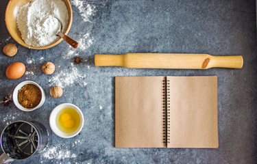 Baking background with empty book  and ingredients for baking eggs, flour, sugar and accessories. Free space for text