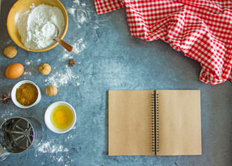 Baking background with empty book  and ingredients for baking eggs, flour, sugar and accessories. Free space for text