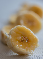Sliced juicy banana on a paper kitchen napkin. Sweet fruit ingredient. Macro shot