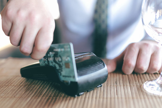 Payment with credit card - man put the credit card into a reader in vintage color tone effect
