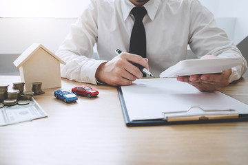 Businessman working doing finances and calculation cost of real estate investment while be signing to contract, Concept mortgage loan approval