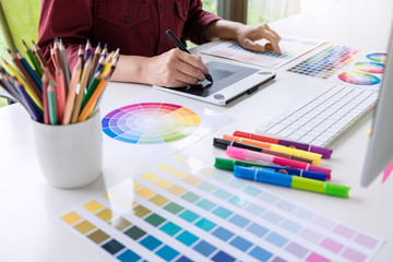 Image of female creative graphic designer working on color selection and drawing on graphics tablet...
