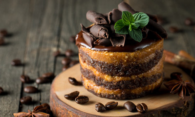 Chocolate cakes on black slatter board with mint, coffee beans on dark background, closeup photo. Fresh, tasty dessert food concept. 