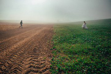Obraz premium Wedding couple running against each other in autumn field. Happy, funny couple photo